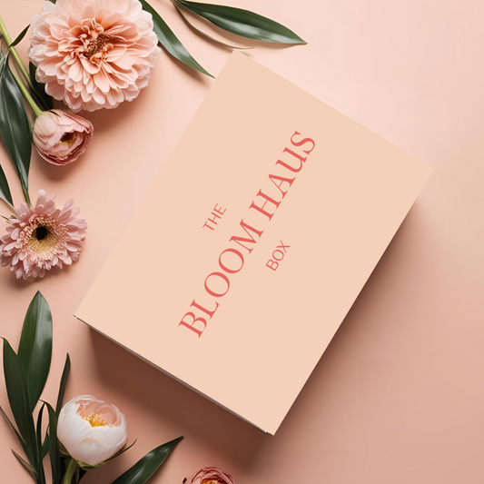 Flat lay of Bloom Haus Box - summer edition featuring candle, dishtowel, cup, lavender sachet and styling card on soft background. 